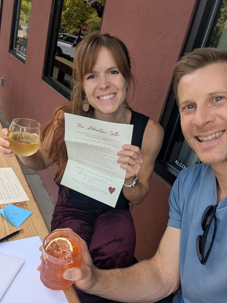 Juliana and John smiling with The Adventure Oath document on their first adventure